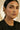 Woman wearing gold Indian earrings with a blurred background