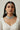 Woman wearing a detailed Indian rhodium plated choker necklace and earrings against a neutral background