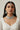 Woman wearing a detailed Indian rhodium plated choker necklace and earrings against a neutral background