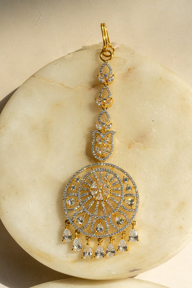 Round-shaped maang tikka with teardrop AD stones in gold plating with white accents from Inaury