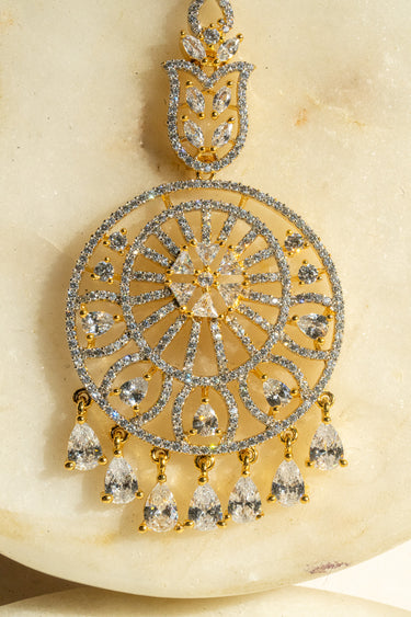 Round-shaped maang tikka with teardrop AD stones in gold plating with white accents from Inaury