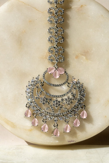 Close-up of Liza Rhodium-Plated AD Maang Tikka in pink, showcasing intricate CZ detailing and delicate petal-shaped drops.