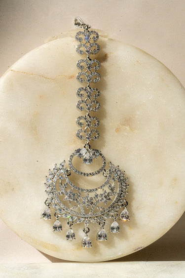 Liza Rhodium AD Maang Tikka in white with teardrop CZ stones, offering a versatile accessory for traditional outfits.