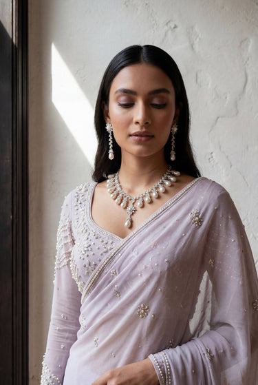 Close-up of the Inaury Saffina Set showcasing the brilliant craftsmanship of the rhodium-plated necklace, teardrop pearls, and matching dangling earrings.