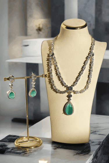 Nira Double Layered AD Necklace Set with criss-cross pattern, large teardrop pendant, and matching earrings in silver and mint green, silver and light pink, or silver and maroon.