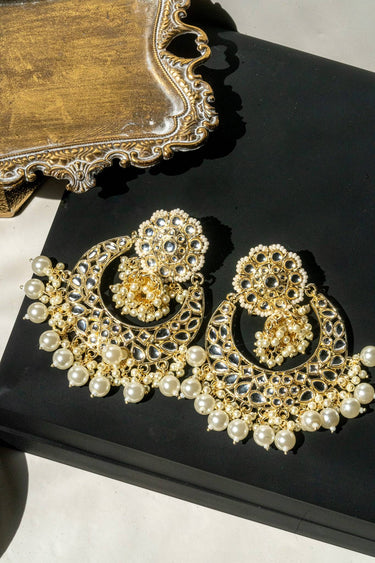 Nura Kundan Chandbali earrings displayed on black surface