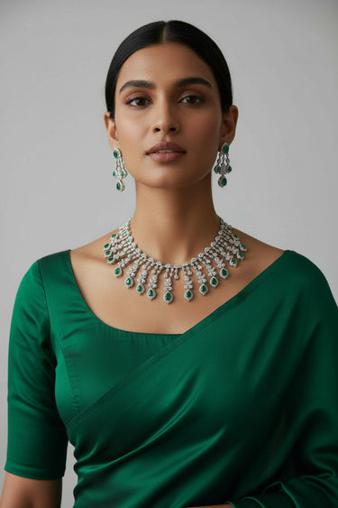 Raha Diamante Accent Classic Necklace Set with emerald green stones styled with green saree