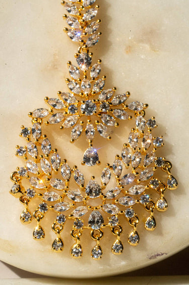 Reema maang tikka in gold with CZ stones and tear-drop accents from Inaury