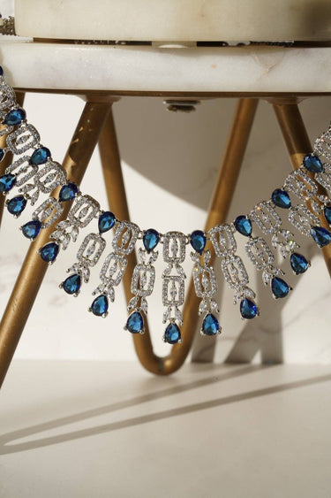 Close-up of Aagya AD Necklace Set – Rhodium Plated in blue, highlighting intricate CZ work and teardrop stones.