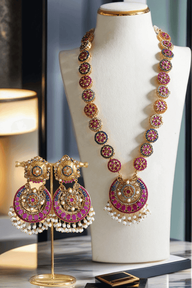Adiva Necklace Set - Gold Mala with multi-color stones and pearl drops, displayed on a bust with matching statement earrings on a stand.