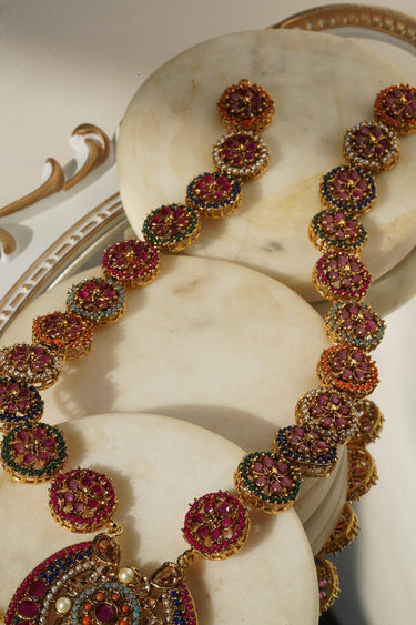 Detailed view of Adiva Necklace chain links with pink, green, and gold stone embellishments in a traditional design.