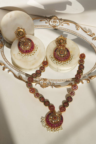 Adiva Gold Plated Long Mala Necklace Set with vibrant stones and pearls, styled on a marble tray with matching earrings.