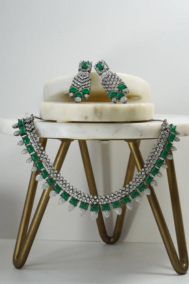 Green Anjam Black Plated AD Necklace Set with earrings, styled on a modern marble stand for a luxurious presentation.