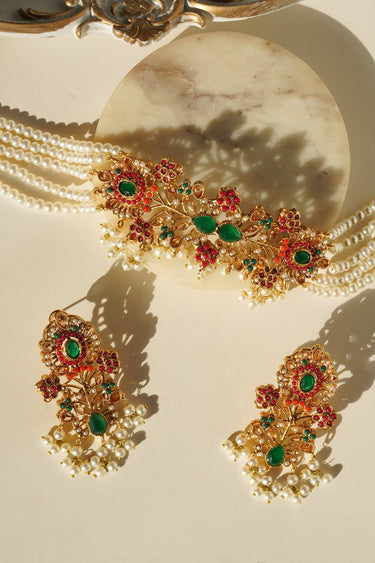 Gold-plated Arushi Pearl Choker Set with green Navratan stones and floral earrings, ideal for South Asian bridal wear.
