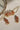 Arushi Pearl Choker Set with pink Navratan stones and floral earrings, laid out on a marble surface.
