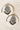 Pair of Esmeray Silver Earrings with black bead fringe and crystal detailing, styled on marble for product showcase.