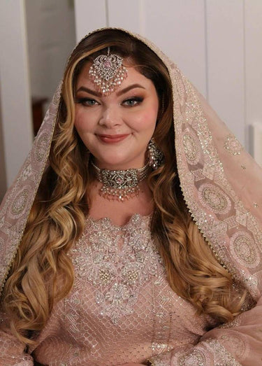 Bride wearing Noreen Choker Necklace Set - Elegant Pakistani Bridal Jewels in silver and pink, styled with traditional embroidered bridal attire.