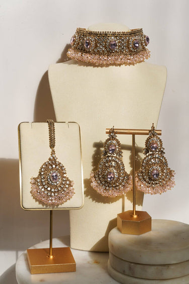 Pink gemstone Rimmie Artisan Crafted Choker Set with matching earrings and pendant, displayed on cream jewelry stand.