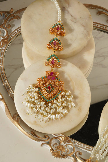 Maang Tikka from Sanjana Set with detailed goldwork, pearls, and vibrant stones, highlighting South Asian jewelry elegance.