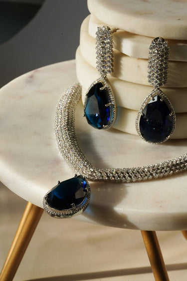 Sharmine Paved Silver Diamanté Accent Necklace Set - Rhodium-plated with Diamanté stones, featuring a large teardrop stone and chandelier earrings, available in multiple color options, perfect for modern South Asian ensembles.