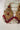 Side view of Sidra Earrings in antique gold with red CZ stones and pearl-red bead fringe, part of Pakistani Jewelry collection.