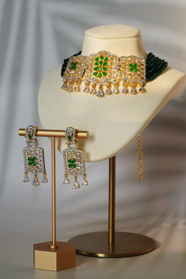 Sumra Gold & Pearl Choker Necklace Set featuring green gemstone detailing and matching earrings, displayed on a bust. Ideal for traditional attire.