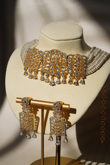 Sumra Gold & Pearl Choker Necklace Set with cubic zirconia and faux pearls, displayed on a bust with matching earrings. Elegant jewelry for occasions.