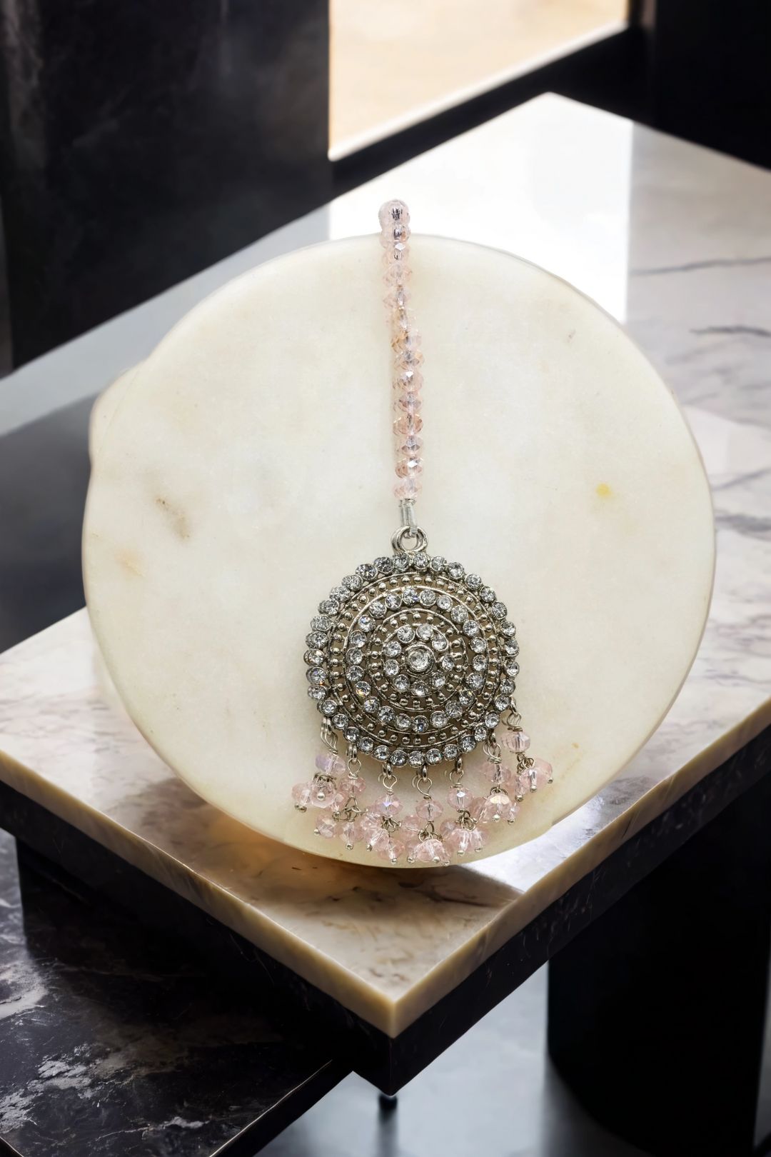Matching silver Tabiha Maang Tikka with pink beads, complements the Jhumka earrings in the traditional jewelry set.