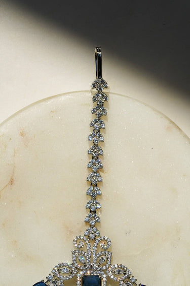 Close-up of the Inaury Isata oversized rhodium-plated maang tikka with sapphire blue and white AD stones – South Asian bridal headpiece