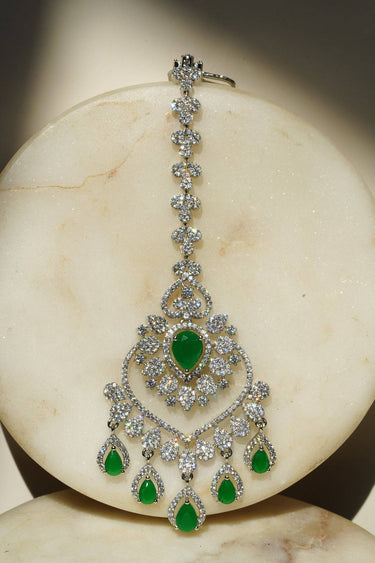 Close-up of the oversized Rhodium plated American Diamond Maang Tikka with green and white crystal teardrop dangles