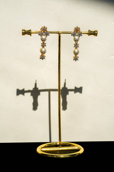 Chhavi Pearl & Diamante AD Earrings displayed on stand