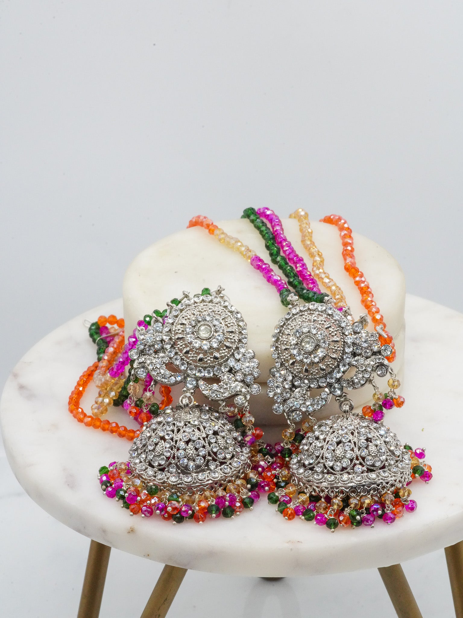 Multicolor beaded earrings from Namar Choker Necklace Set with silver CZ detailing, displayed on marble base.