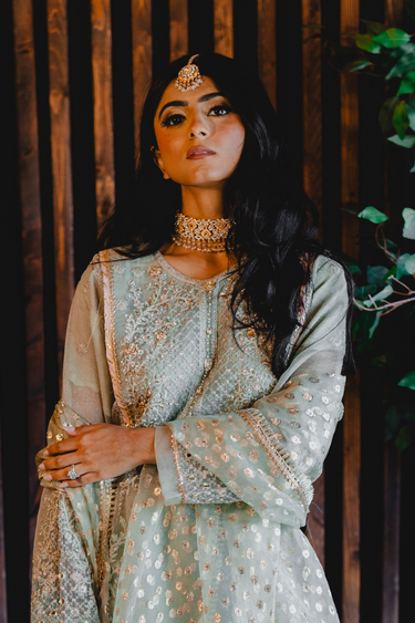 Model in pastel outfit styled with Ayesha Choker Necklace Set, featuring earrings and Maang Tikka for a complete ethnic look.