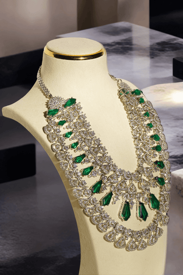 Ashma Bridal Set - Multilayer rhodium-plated silver finish with emerald green stones, including choker and multi-layered necklace.