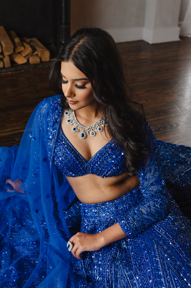 Model wearing Purvi Diamante Necklace Set - Bridal Indian Jewelry in blue with matching lehenga, perfect for weddings and special occasions.