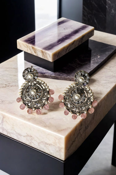 Flat-lay of Navya Black Plated Chandbali Earrings with pink beads and pearl detailing, great for traditional and bridal looks.