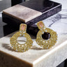 The Mia - Dainty Chandbali Earrings with CZ Stones in gold and blush pink, displayed on a marble surface for a luxurious jewelry look.