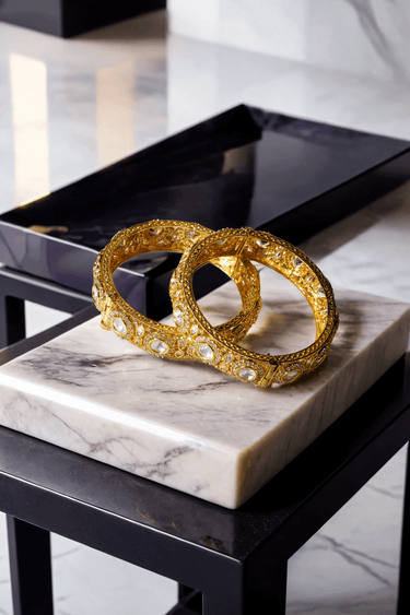 Tamina Moissanite Polki Bangles - Heritage Style | Openable pair of gold bangles resting on marble, showcasing luxurious moissanite detailing.