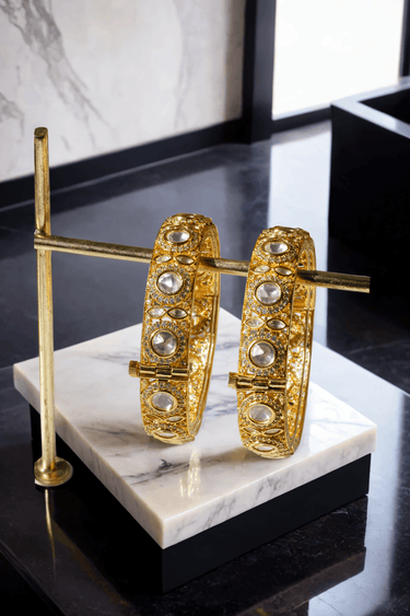 Tamina Moissanite Polki Bangles - Heritage Style | Openable bangles hanging vertically on gold rod, highlighting symmetrical polki stone layout.