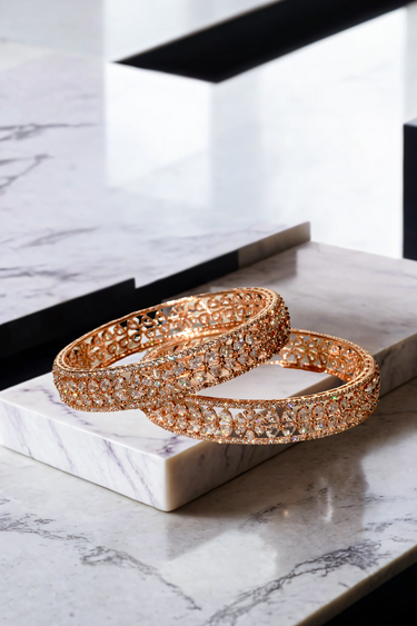 Elegant Myra Rose Gold AD Bangles set of 2 featuring intricate floral petal motifs and sparkling accents on a marble surface.