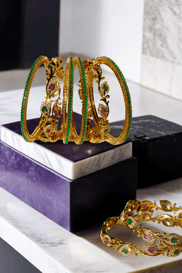 Norea 6-piece gold-plated bangle set with green, ruby, and white stones and intricate floral and vine motifs