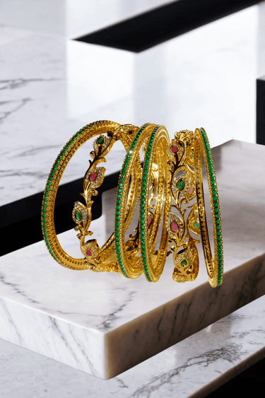 Norea 6-piece gold-plated bangle set with green, ruby, and white stones and intricate floral and vine motifs