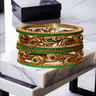 Norea 6-piece gold-plated bangle set with green, ruby, and white stones and intricate floral and vine motifs