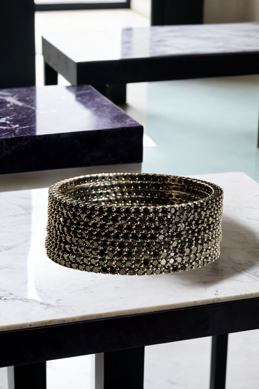 Simran Bangles - Set of 8 Choori Style Black Plated Bangles with Black Stones by Inaury, displayed on a marble surface with luxurious black detailing.