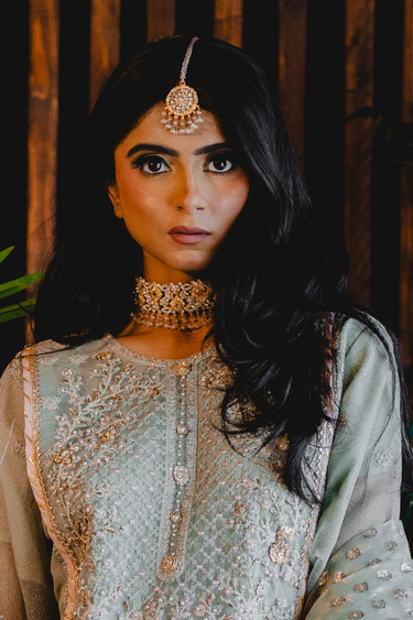 Model wearing Ayesha Choker Necklace Set with Maang Tikka, showcasing its floral design and elegance for traditional celebrations.