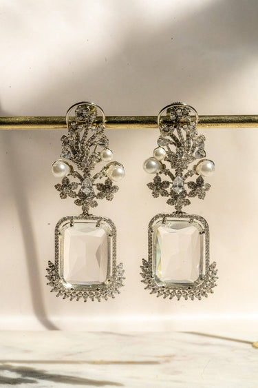 Aayat Statement Earrings in crystal white with pavé halo, pearl accents, and floral rhodium-plated design. Elegant South Asian dangle earrings.