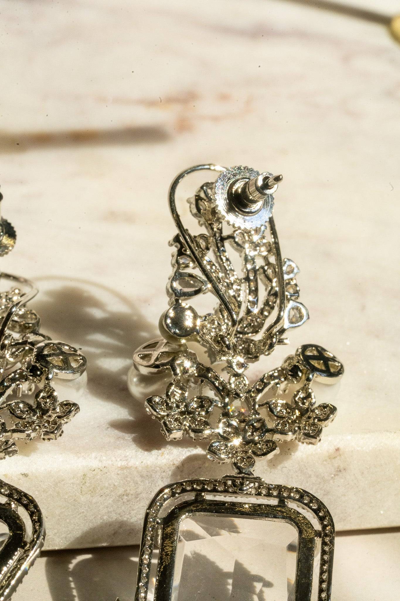 Back view of Aayat Statement Earrings in crystal white showing post closure and detailed rhodium-plated floral structure.