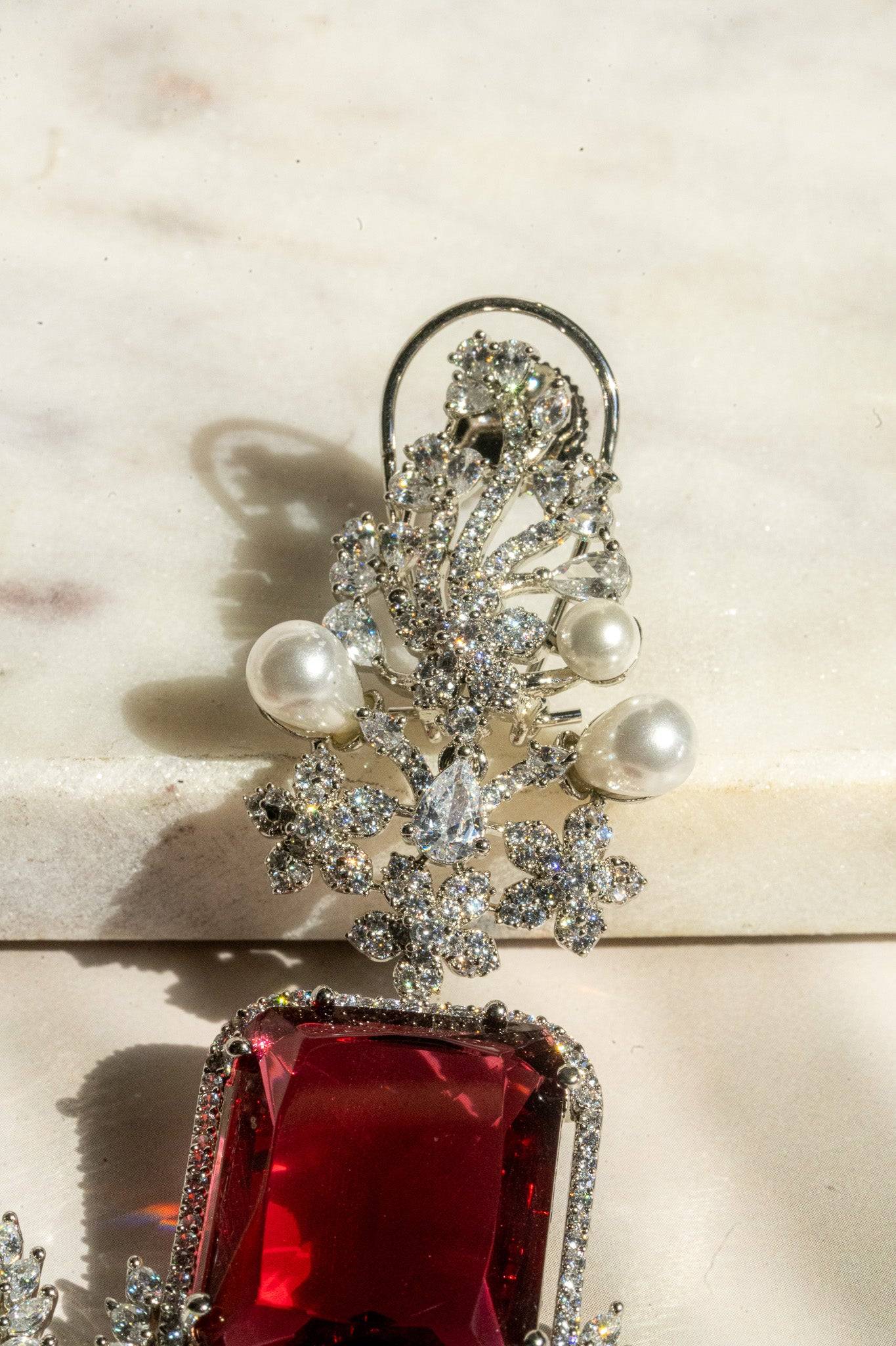 Close-up of upper floral section of Aayat Statement Earrings in ruby red, featuring pavé crystals and pearl embellishments.