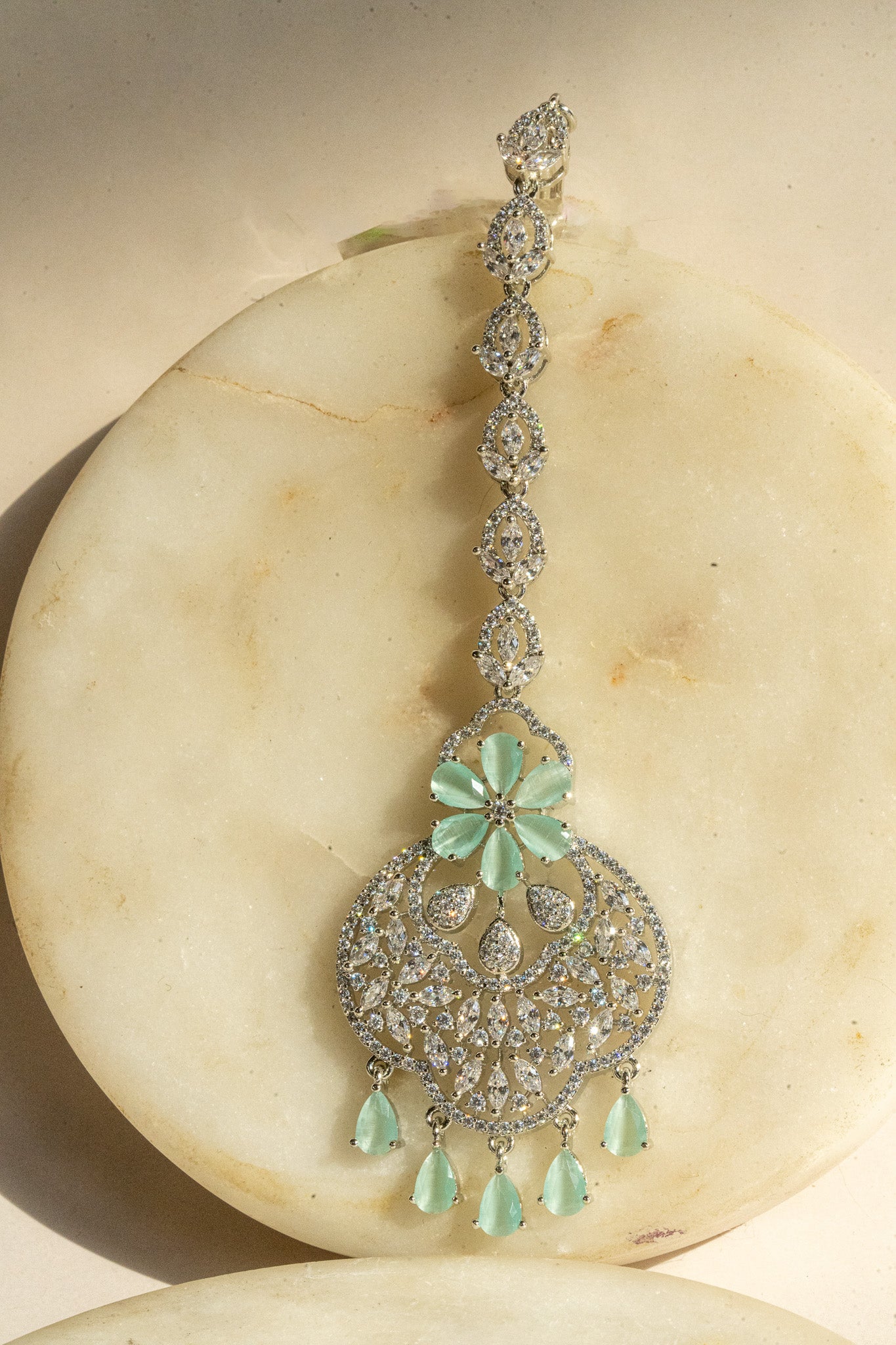 Rhodium-plated floral maang tikka with AD stones in a silver and pink finish from Inaury