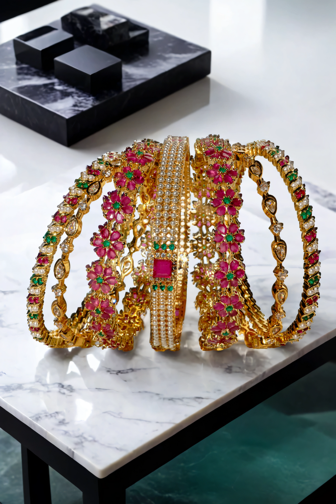 Arika floral gold-plated bangles with ruby and emerald stones arranged elegantly. Ideal for weddings, parties, and festive attire.